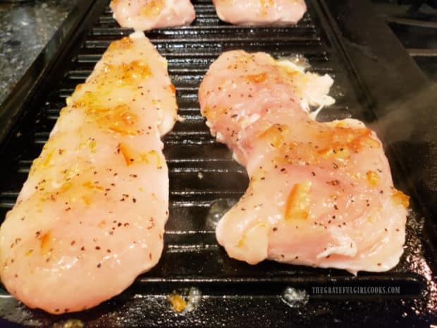Grilled marmalade chicken breasts cooking on indoor grill.