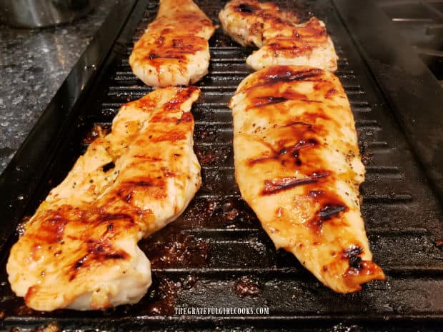 When done, grilled marmalade chicken breasts are browned and coated with sauce.