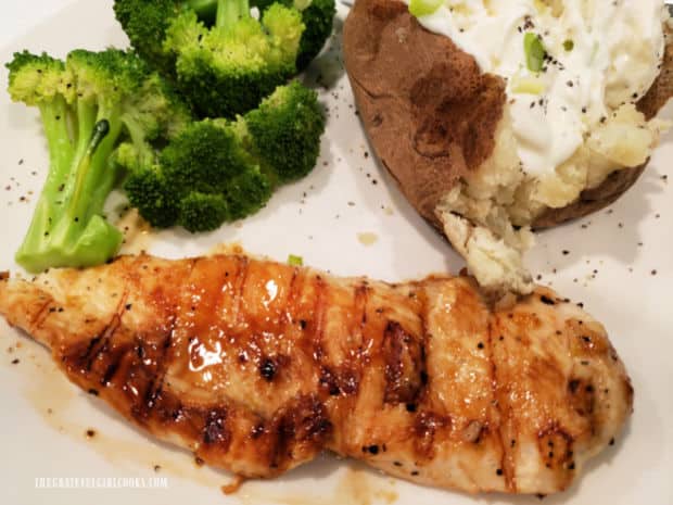 A piece of grilled marmalade chicken, served with baked potato and broccoli.