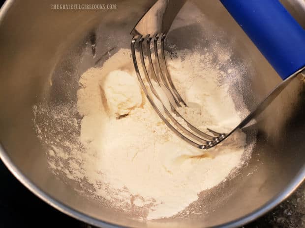 A pastry blender is used to cut vegetable shortening into flour/salt mixture.