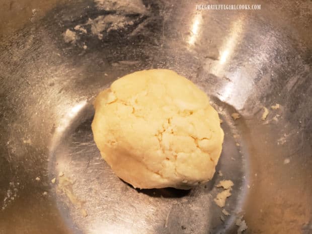 Pie crust dough is shaped into a ball, then wrapped and refrigerated.