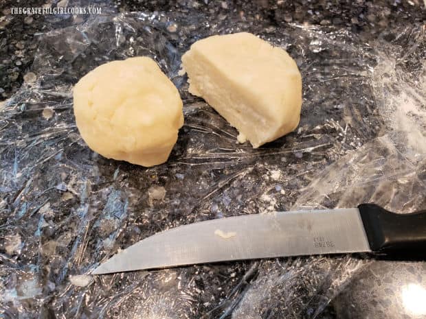 Chilled dough is cut into two pieces to form crust.