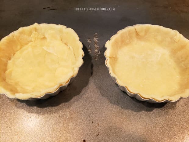 Two little tart pans, filled with the chilled pie dough.
