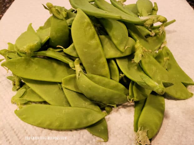 Fresh sugar snap peas need to have the stem ends removed before cooking.