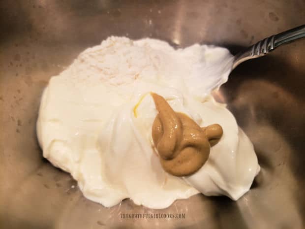 Sour cream, flour and Dijon mustard are combined in a small bowl.