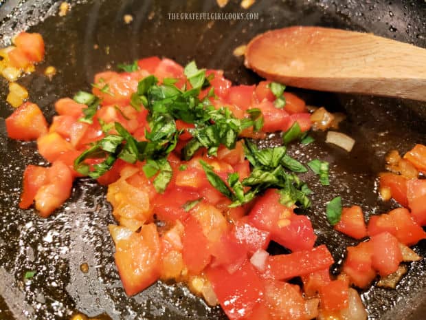 Minced fresh basil is added to the tomatoes and onions in skillet.
