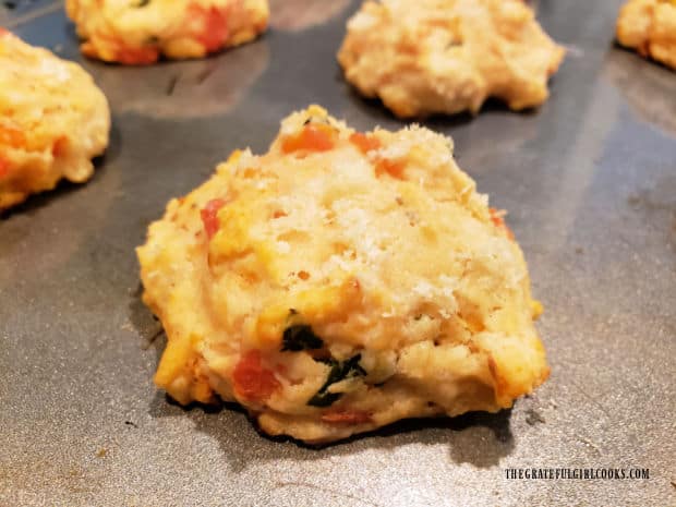 After baking, the tomato basil drop biscuits cool on the baking sheet.
