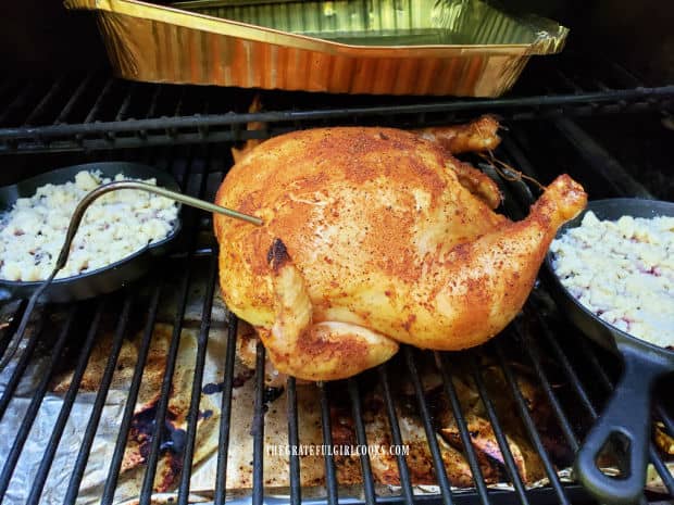 Two blackberry cobbler mini skillets cooking by a roast chicken on Traeger grill.