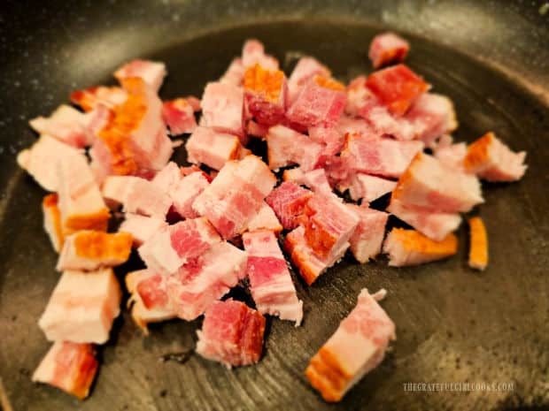 Three pieces of bacon are cut into small pieces then cooked in a skillet.
