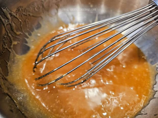 Wet ingredients for muffin batter are whisked together in a bowl.