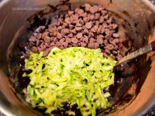 Chocolate chips and zucchini are stirred into chocolate zucchini muffin batter.