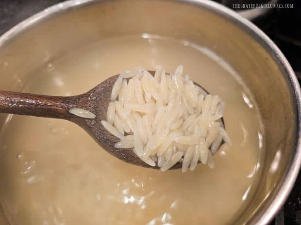 Orzo pasta is cooked in boiling salted water according to package directions.