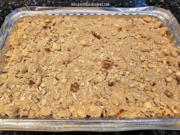 Pecan streusel topping is sprinkled over the surface of the blackberry crisp.