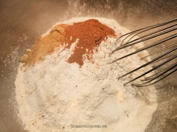 Dry ingredients (flour, spices, etc.) are whisked together in a large mixing bowl.