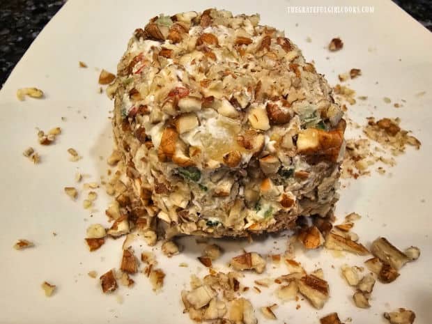 The cheese ball is covered with chopped pecans.