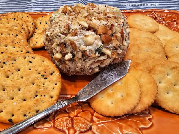 A pecan pineapple cheese ball, served on a platter with assorted crackers.