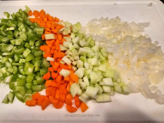 Onion, green apple, celery and carrots are finely chopped for the soup.