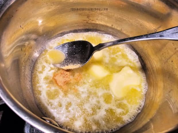 Melted butter in saucepan is combined with garlic powder.