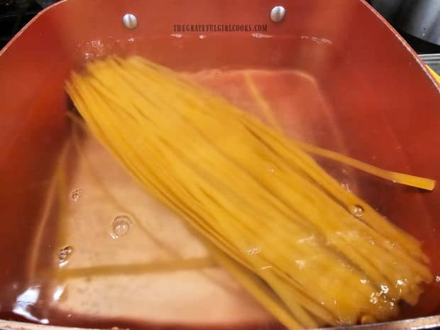 Fettucine pasta is cooked in boiling water according to package instructions.