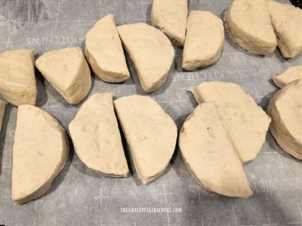 Eight canned jumbo biscuits are cut in half.