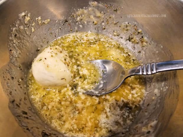 Each dough ball is immersed and covered with the butter herb sauce.