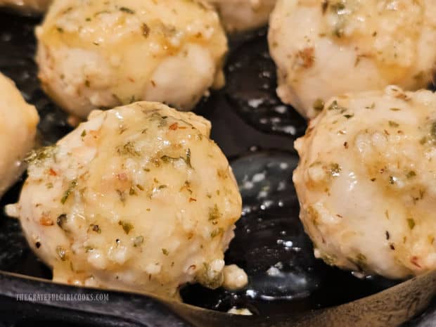 Butter and herb covered dough balls are placed in skillet OR baking dish.