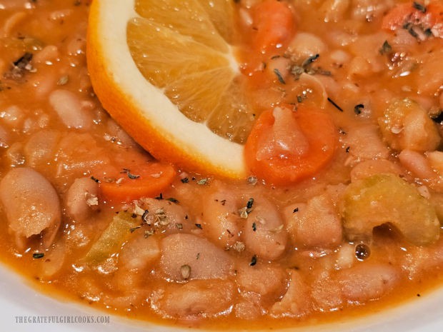 The Greek Cannellini Bean Stew is served with an orange slice as garnish.