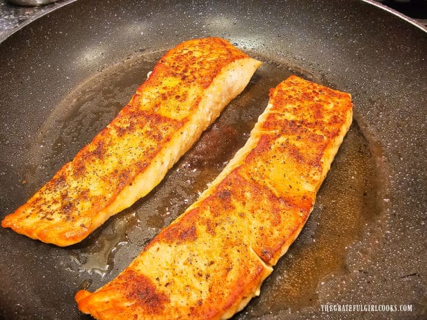 The salmon fillets are flipped over to cook the other side.