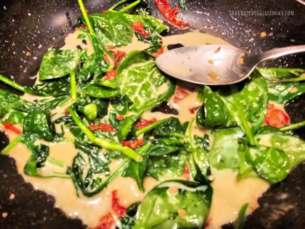 The sauce is done when the spinach has wilted in the skillet.