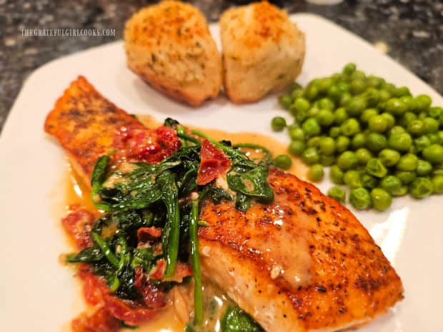 Salmon In Spinach Cream Sauce, served with rolls and peas on the side.