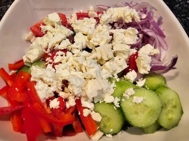 Feta cheese is crumbled into big pieces and added to the top of the salad.