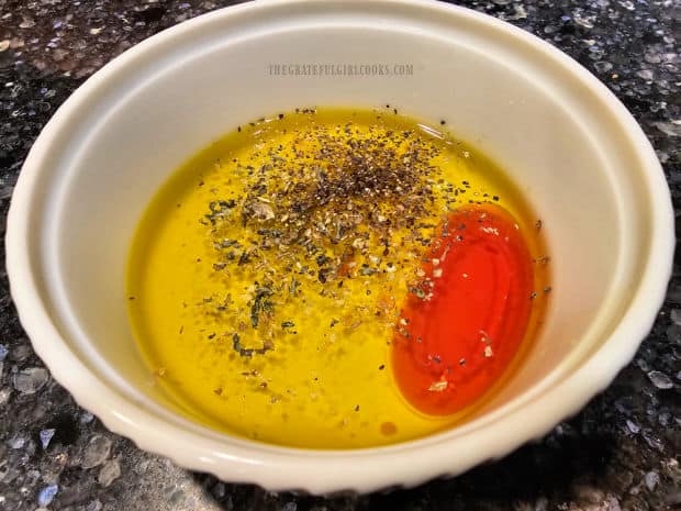 Olive oil, red wine vinegar, lemon juice, oregano, salt & pepper in a small dish.