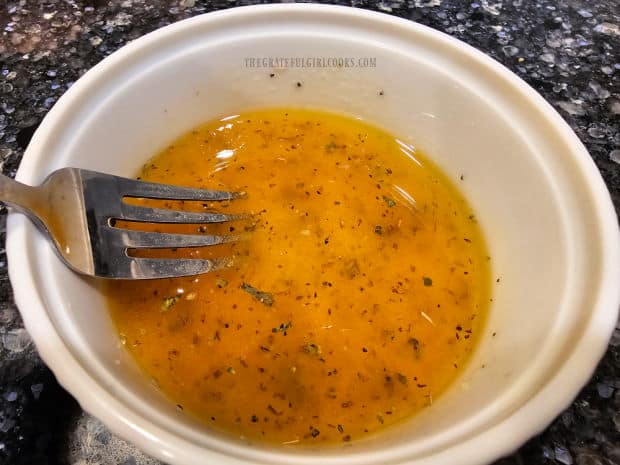 The salad dressing for the traditional Greek salad is mixed using a fork.