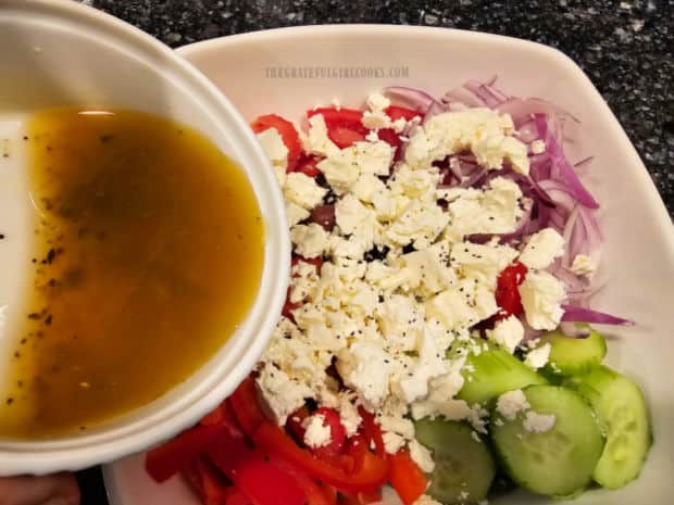 Simple salad dressing is poured over the top of the Greek salad.