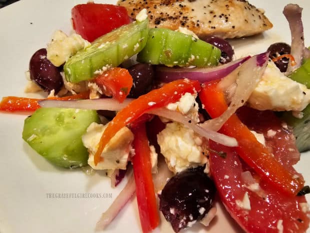 The traditional Greek salad is covered with dressing, and is ready to EAT!