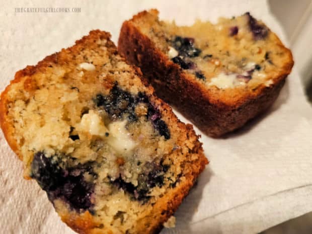 Two slices of blueberry banana bread, with melted butter on top.