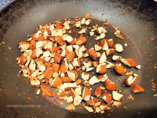 Chopped almonds are dry-toasted in a hot skillet for 3 minutes.