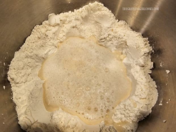 Yeast mixture is added to the well of a flour and salt mixture.