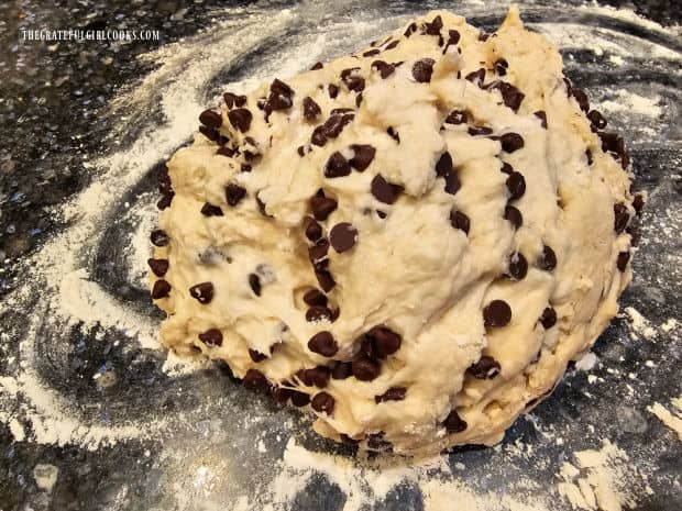 The chocolate chip bagel dough is put on a floured surface to knead.