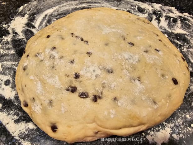 The risen dough is placed on a lightly floured surface to cut into 8 pieces.