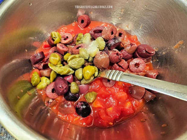 A sauce is made with diced tomatoes, olives, capers, sugar and lemon juice.