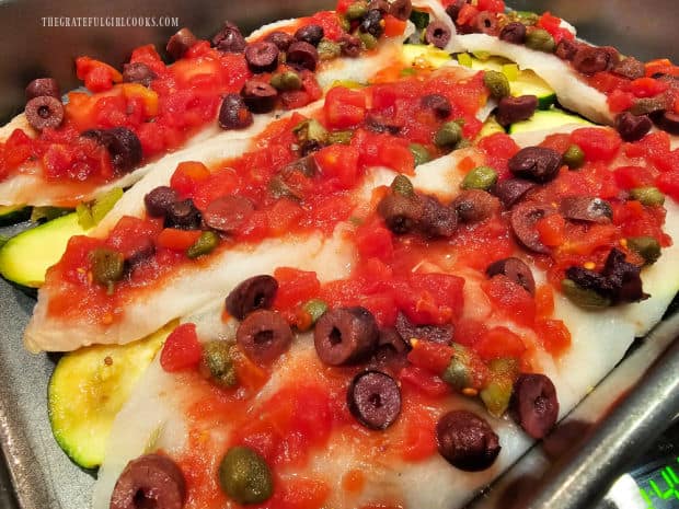 Sauce is divided evenly over the top of each piece of fish in the baking dish.