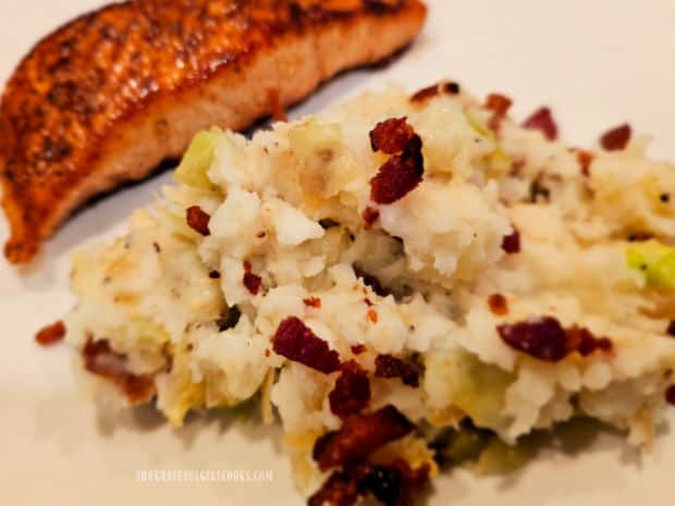 Salmon fillet is served with the Irish colcannon with bacon on plate.