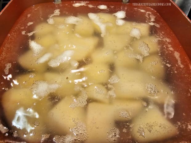 Peeled, chunky potatoes cook in salted, boiling water until tender.