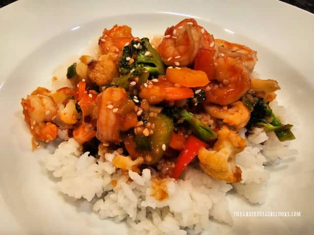 A white bowl with white rice, topped with the Szechuan Shrimp Stir-Fry.