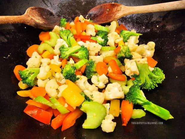 Stir-fried vegetables are cooked until slightly tender in pan.