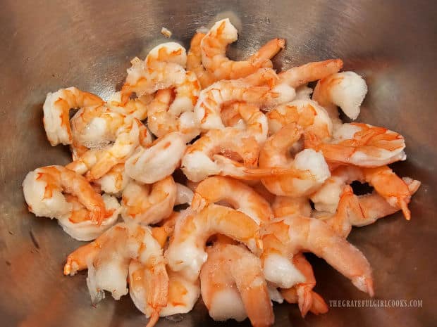 Frozen pre-cooked shrimp are thawed, then patted dry before cooking.