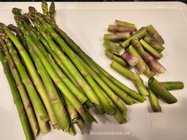 The "tough" ends of the asparagus are cut or snapped off.