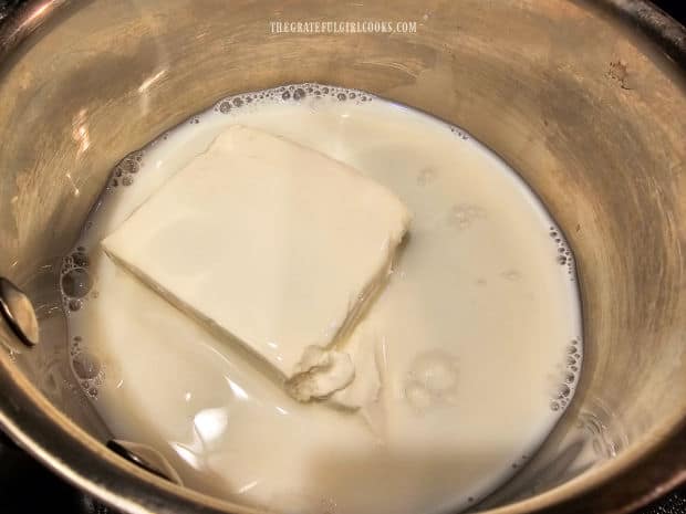 Cream cheese and milk are cooked on low heat until cream cheese has melted.