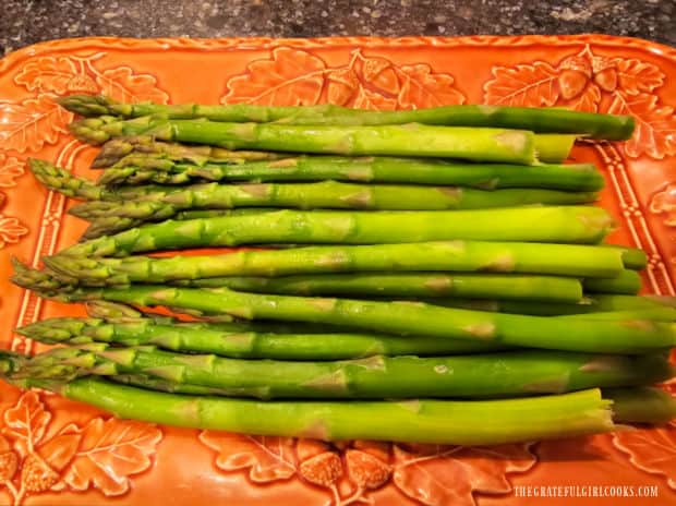 Cooked and hot, crisp-tender asparagus is transferred to serving platter.